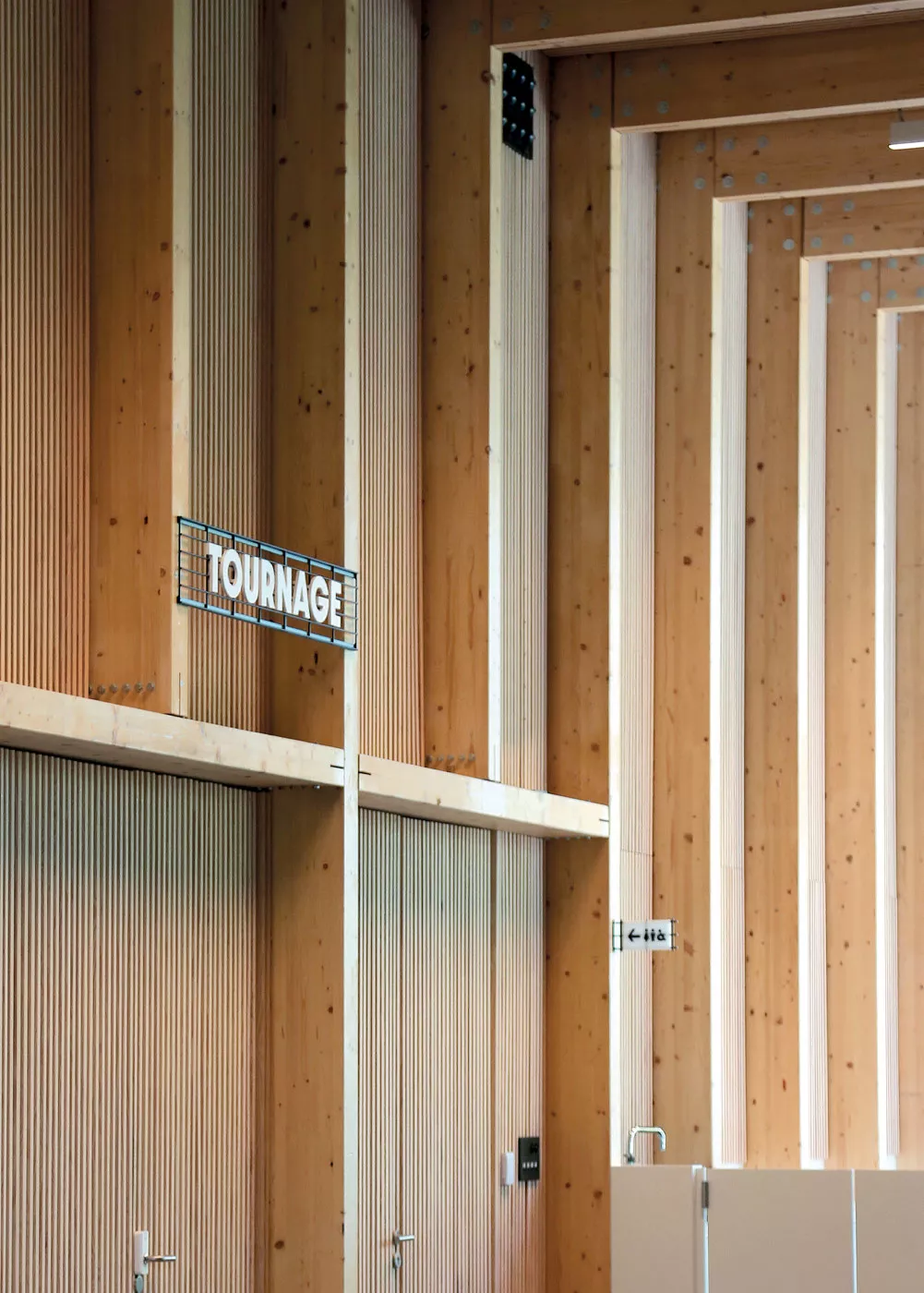 Lettrage en relief appliqué à une façade en béton brut